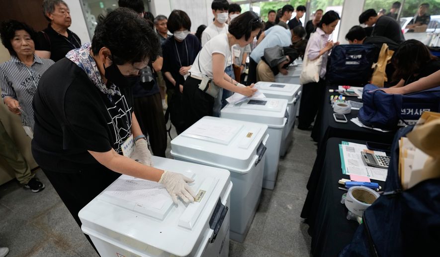 026年6月3日水曜日、韓国ソウルの体育館で、韓国中央選挙管理委員会の職員が地方選挙の投票用紙が入った箱を確認している。(AP通信/アン・ヨンジュン)