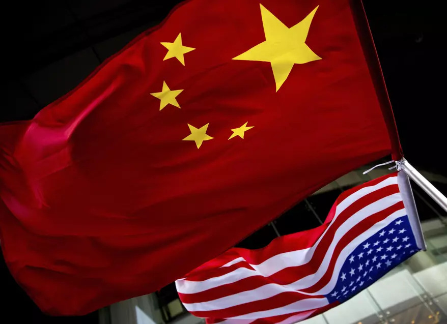 北京の米国大使館が主催した米大統領選挙関連イベント中、ホテルの外に米国と中国の国旗が掲げられた。政府報告書は、中国、ロシア、イランの諜報機関が、米国の企業、政府研究所、大学から企業秘密や専有情報を盗もうと躍起になっている様子を明らかにしている。(AP通信/アンディ・ウォン)