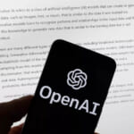 2023年3月21日、ボストンにて、ChatGPTの出力画面が表示されたコンピュータ画面の前に置かれた携帯電話に、OpenAIのロゴが表示されている。(AP通信/マイケル・ドワイヤー撮影、資料写真)